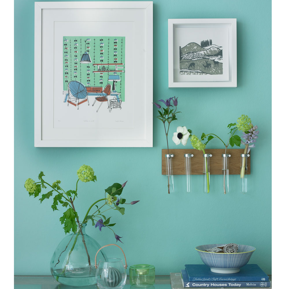 green living room gallery wall with art prints and wall-mounted flowers