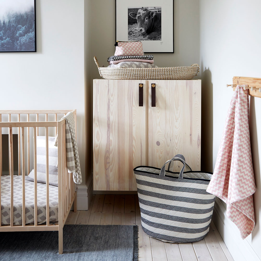 grey nursery with wooden floorboards and stripped back wooden furniture