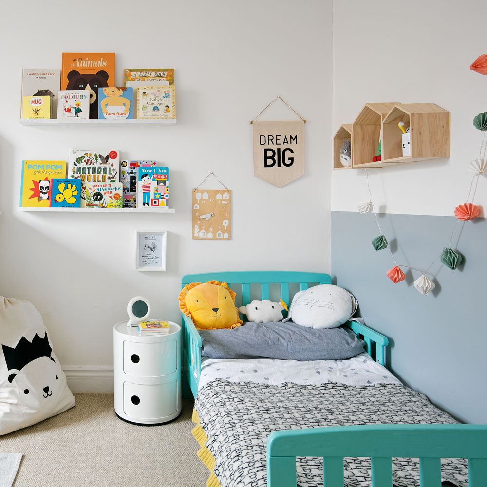 kids room with white and grey walls blue bed and book shelves