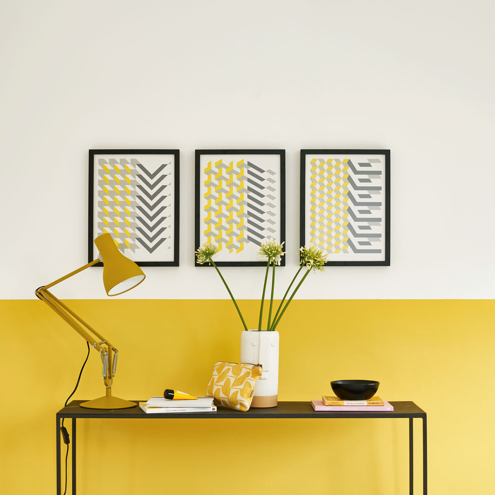 Yellow and grey wall with sideboard and wall art